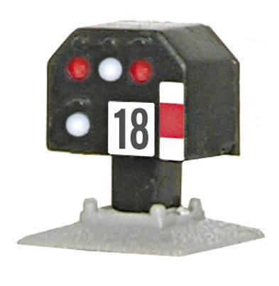 Un panneau de signalisation avec le numéro '18' et des lumières rouges indique un signal d'arrêt ou de limitation de vitesse.