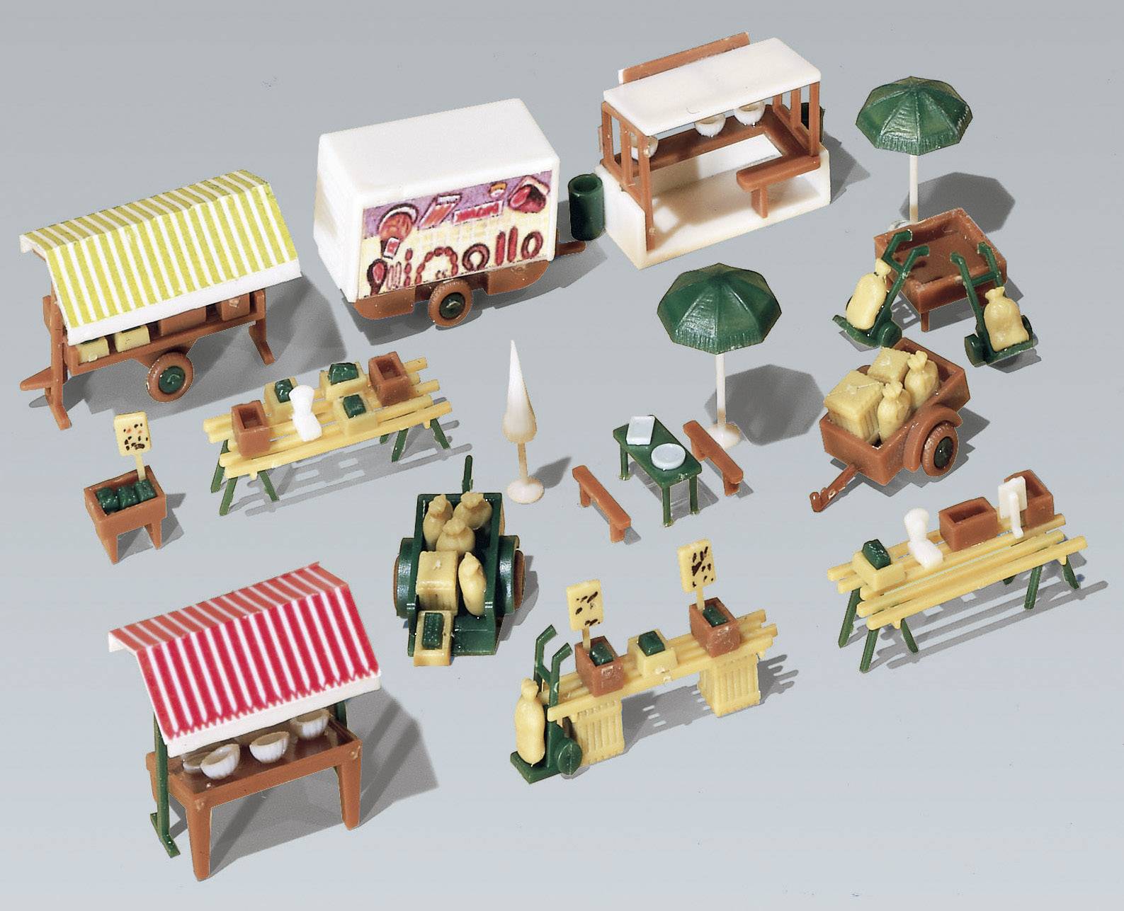 Plusieurs petites échoppes et stands en format miniature, comprenant des étals de marché avec des auvents, des tables garnies de nourriture et des parasols décoratifs.