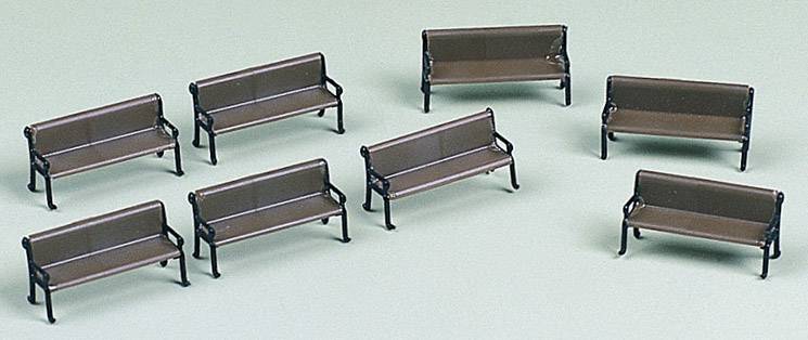 Huit petits bancs bruns sont répartis sur une surface vert clair. Les bancs ont des accoudoirs noirs.