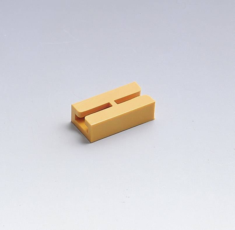 Un objet en plastique orange en forme de H est posé sur une surface blanche.