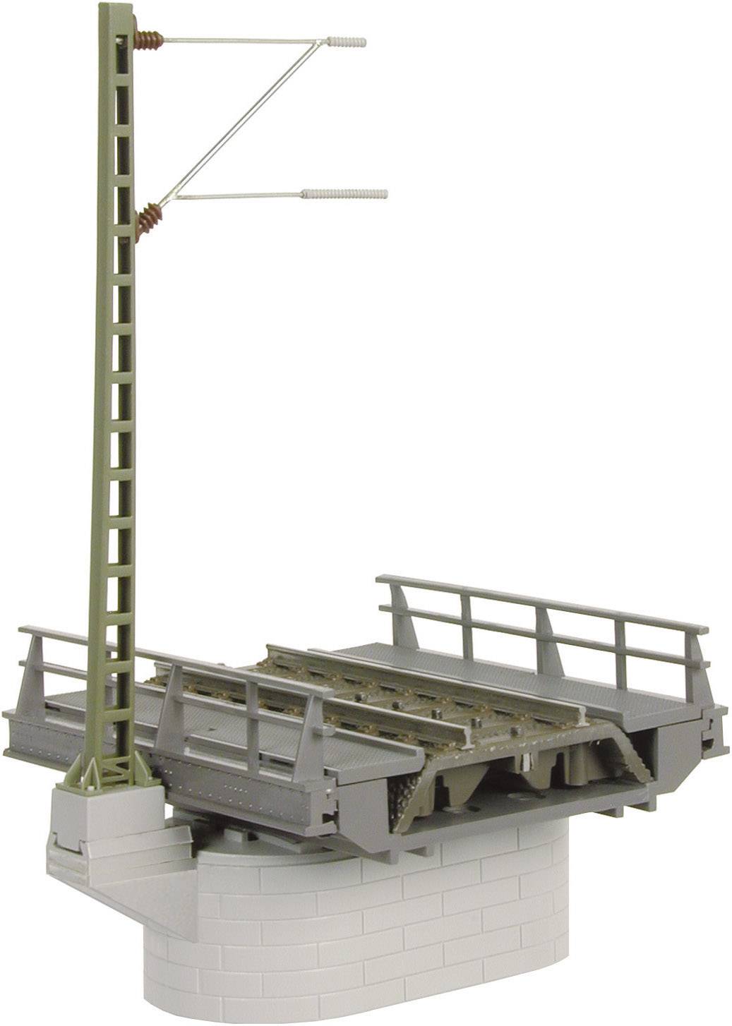 Un modèle de pont de chemin de fer avec une ligne verte et des rails gris sur un socle gris et rond.