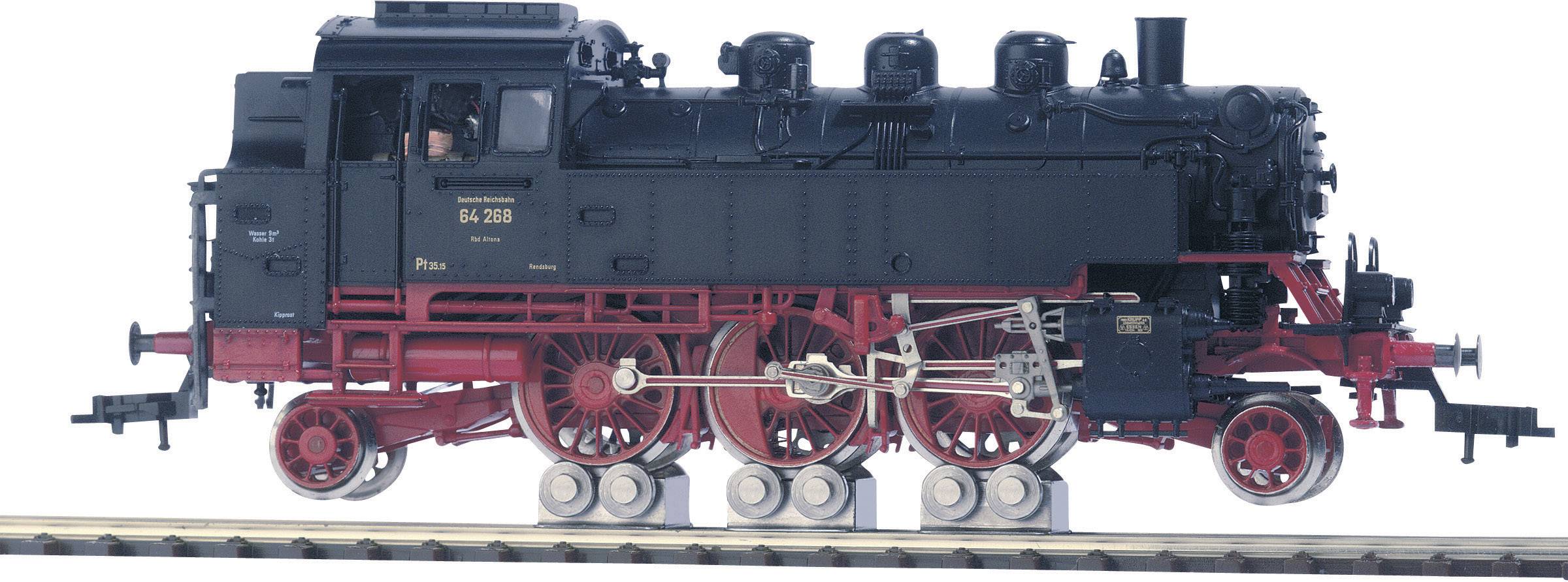 Une locomotive à vapeur noire sur des rails, avec des roues rouges et des détails mécaniques visibles. Une personne est reconnaissable dans la cabine de conduite.