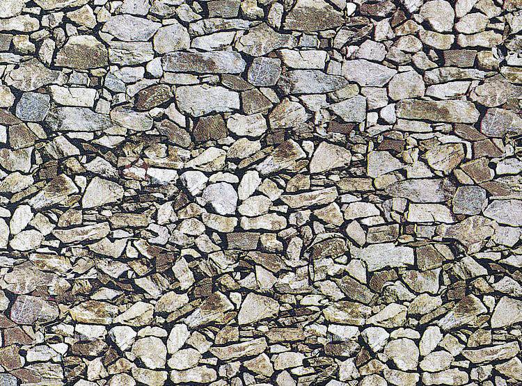 Un mur composé de pierres naturelles aux formes irrégulières, empilées de manière dense et sans interstices, présentant différentes nuances de brun.