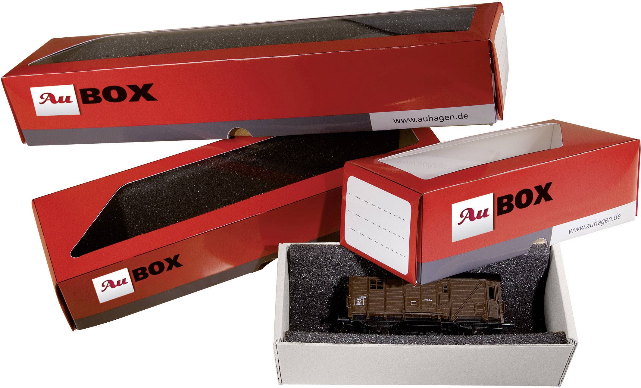 Trois boîtes rouges de la marque 'AuBox' avec une boîte ouverte. La boîte ouverte contient un modèle de wagon de marchandises.