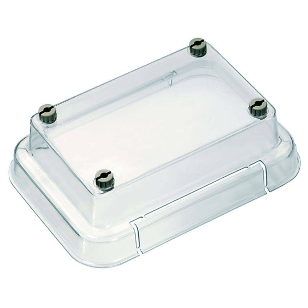 Couvercle en plastique transparent sur un récipient rectangulaire. Quatre vis sombres aux angles du couvercle.
