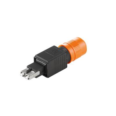 Un adaptateur noir à trois broches métalliques repose sur une surface blanche devant un boîtier orange.