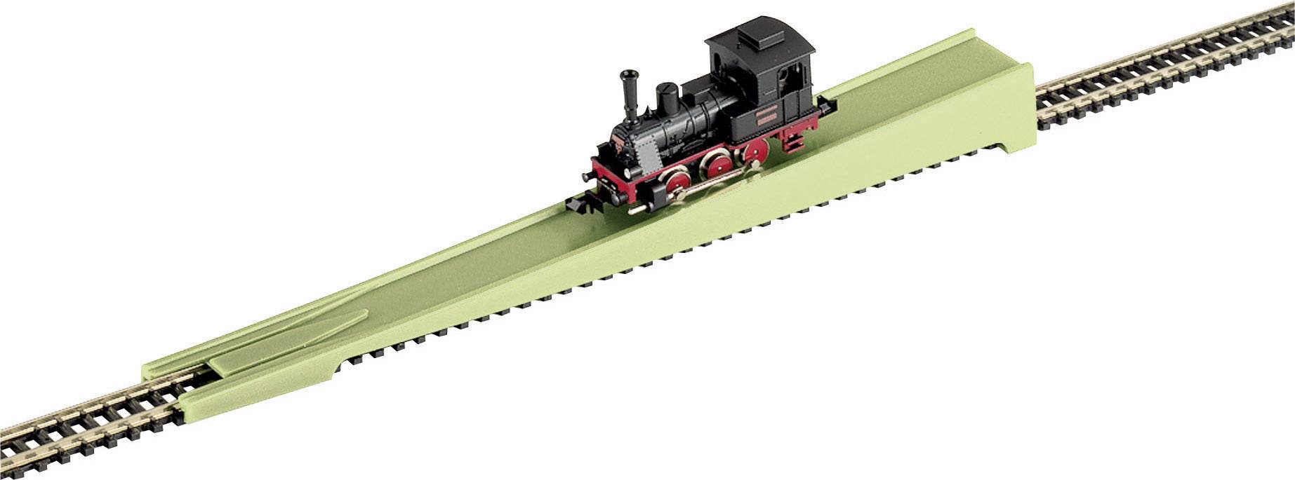 Petit train miniature sur un tronçon de voie ferrée vert, faisant partie d'un système de train miniature.