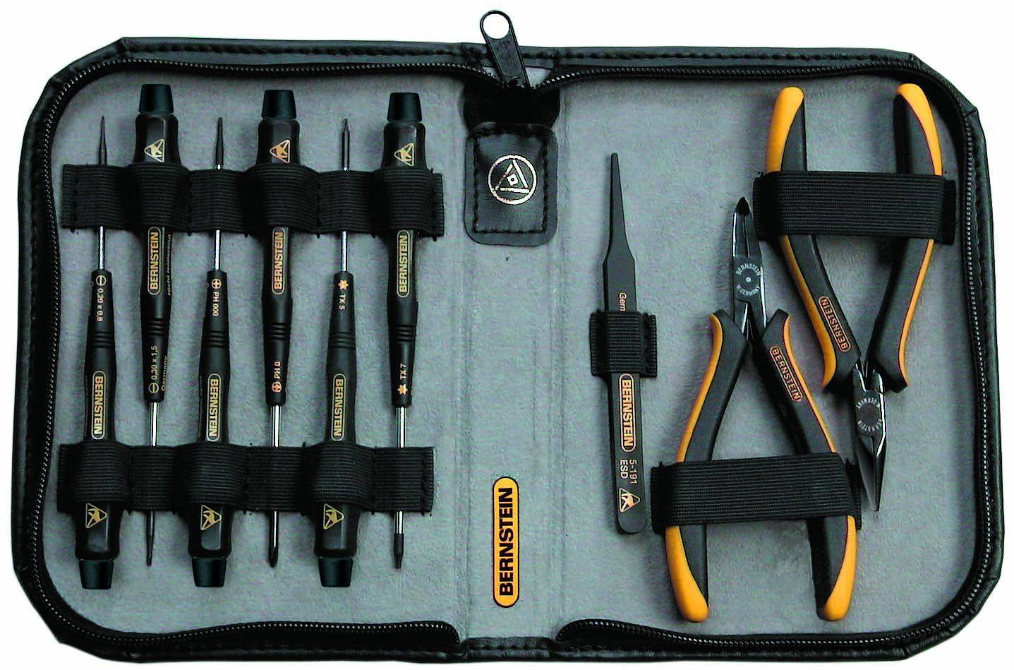 Un ensemble d'outils ouvert comprenant des tournevis, une pince et des pinces, tous disposés dans un étui noir avec un doublure intérieure grise.