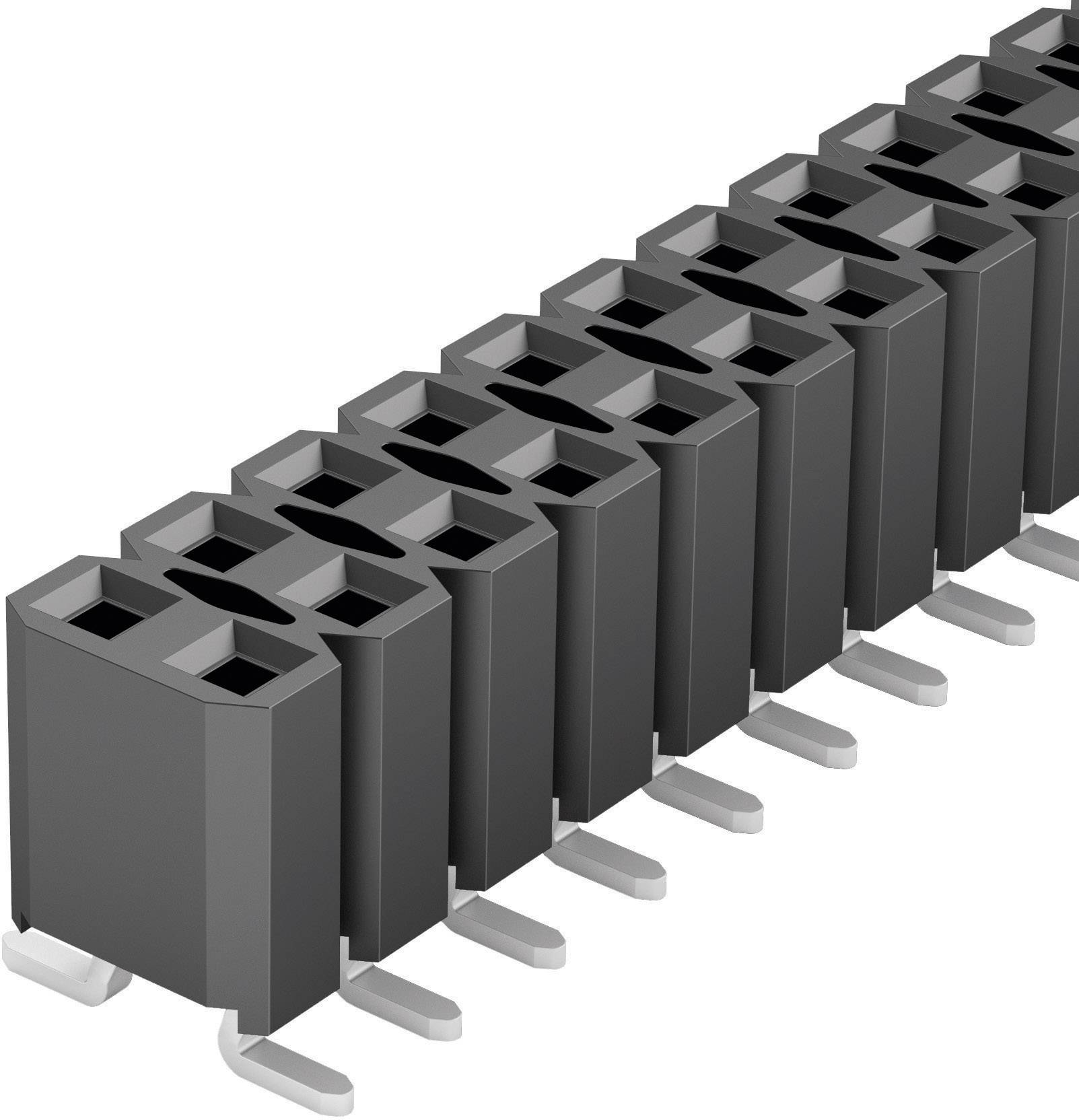 Une rangée de connecteurs électriques noirs à broches multiples, disposés verticalement et posés sur une surface plane.