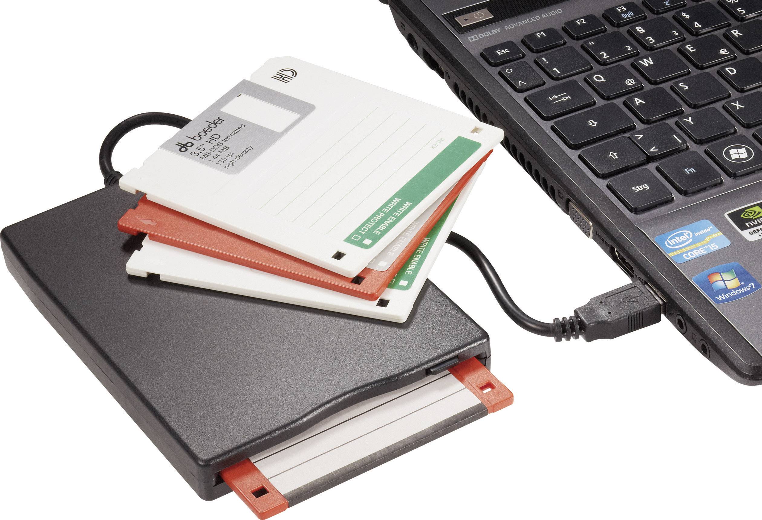 Lecteur de disquettes externe avec plusieurs disquettes, connecté à un ordinateur portable. Logo de la marque visible sur le clavier.