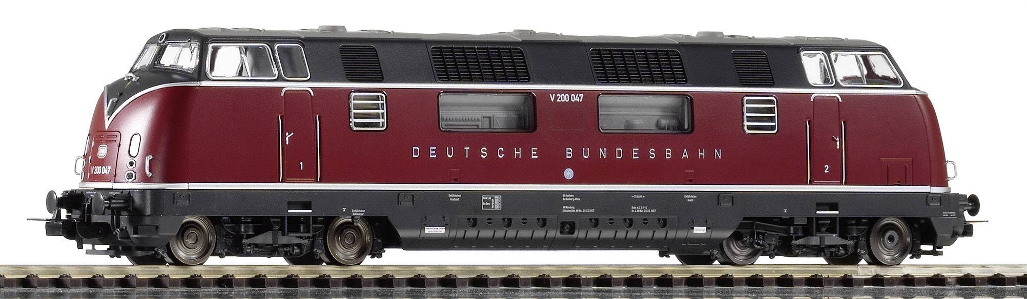 Une locomotive rouge de la Deutsche Bundesbahn sur une voie ferrée, vue de côté.