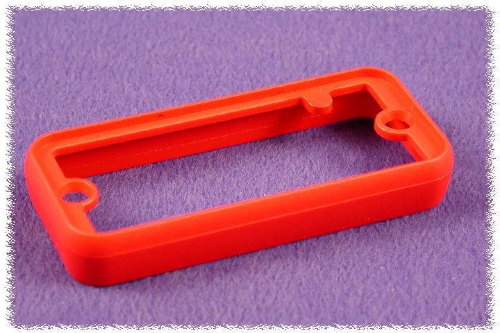 Un cadre en plastique rouge, rectangulaire avec des coins arrondis, posé sur un fond lilas.