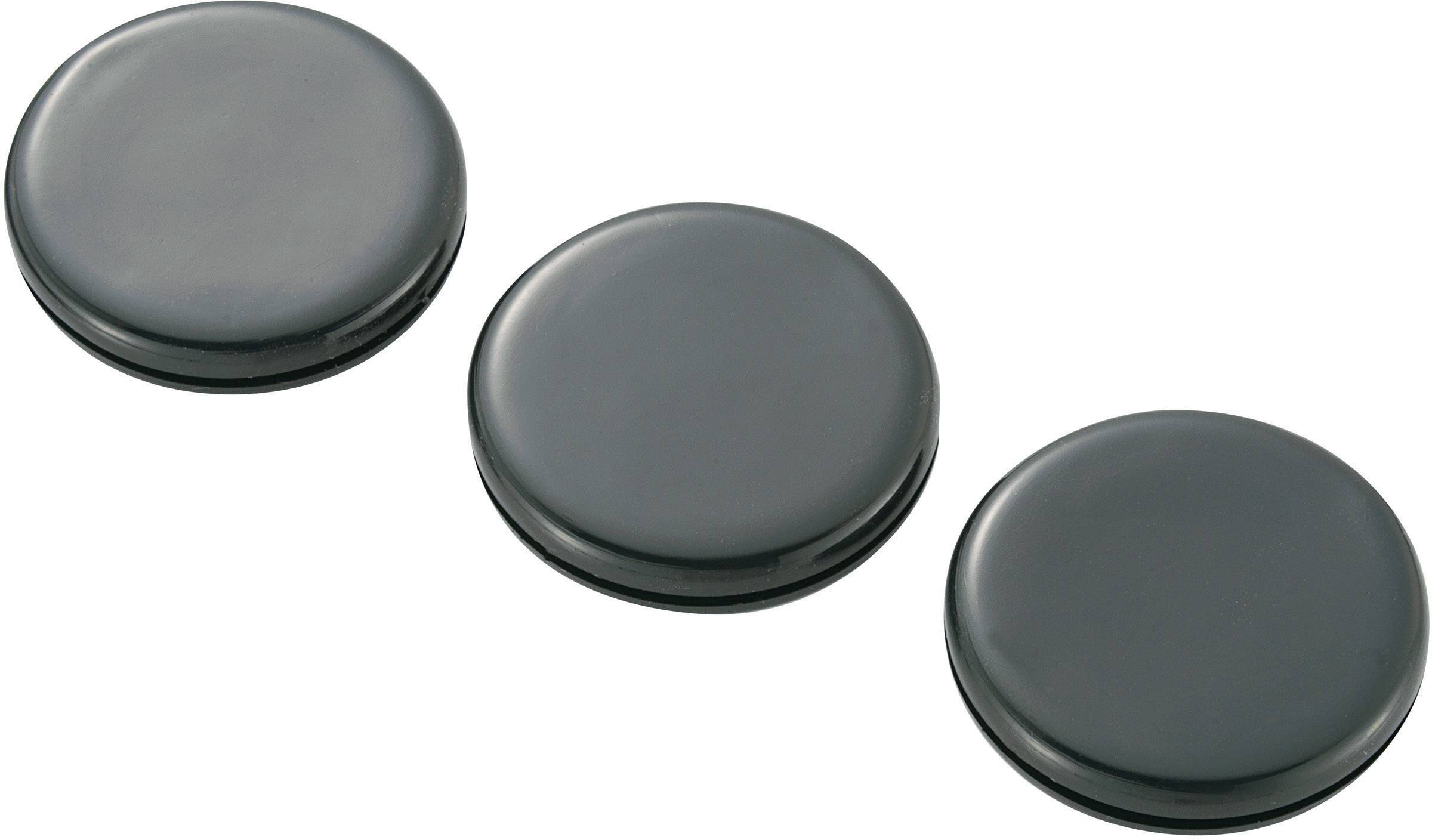Trois aimants noirs ronds, disposés uniformément les uns à côté des autres.