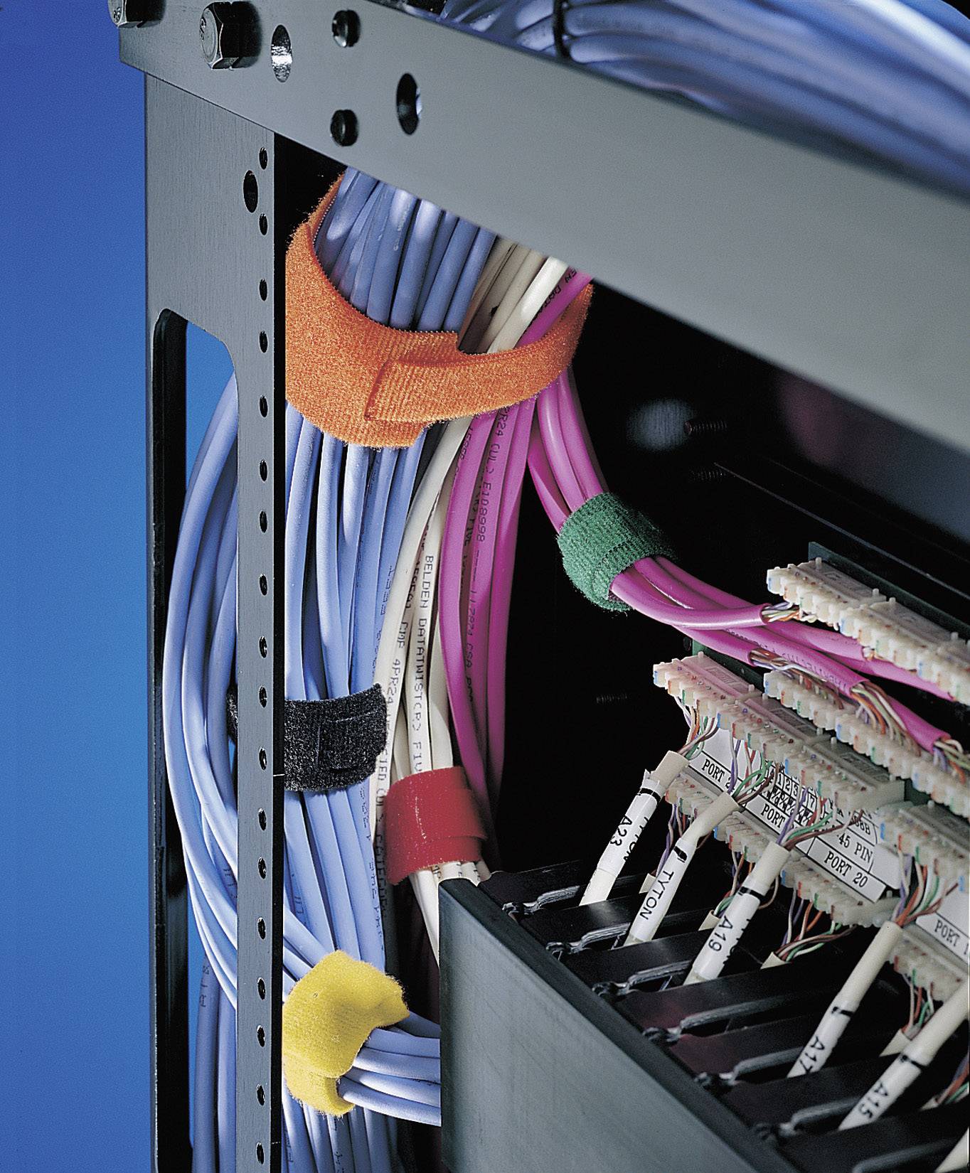 Câblage réseau dans un rack serveur, sécurisé avec des attaches de câbles de différentes couleurs, montrant un agencement des câbles ordonné et structuré.