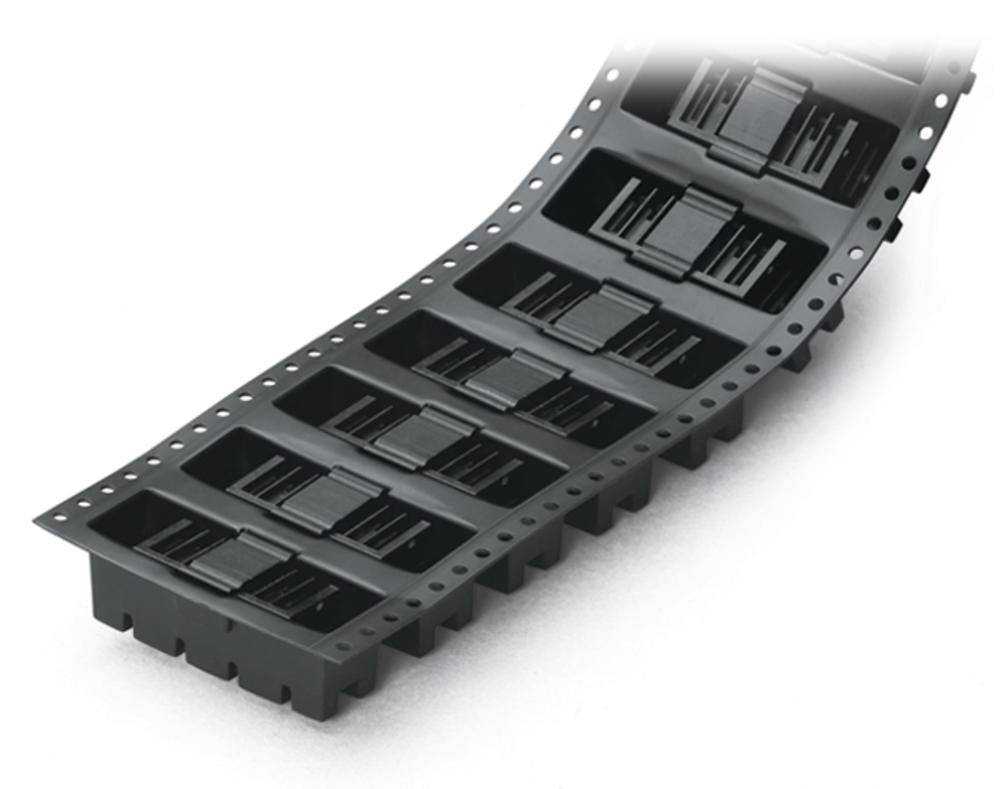 Emballage en plastique noir avec des puces électroniques intégrées, disposées en ligne, présentant une forme flexible adaptée aux processus de montage automatisés.