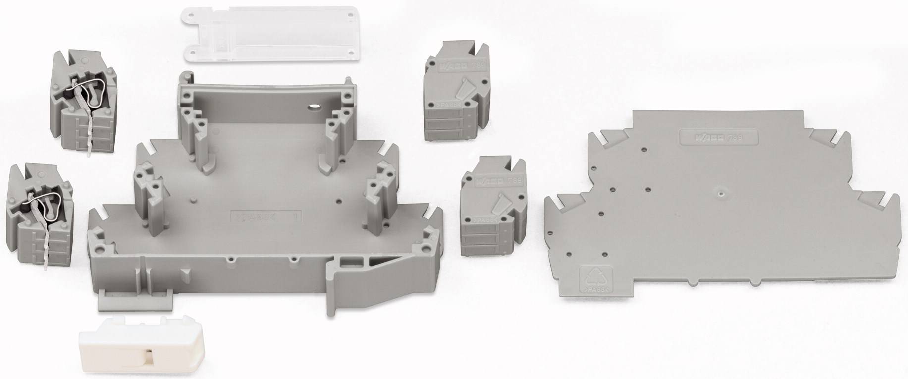 Composants en plastique gris sur fond blanc. Différentes formes et tailles, probablement des pièces d'un appareil ou d'un boîtier.