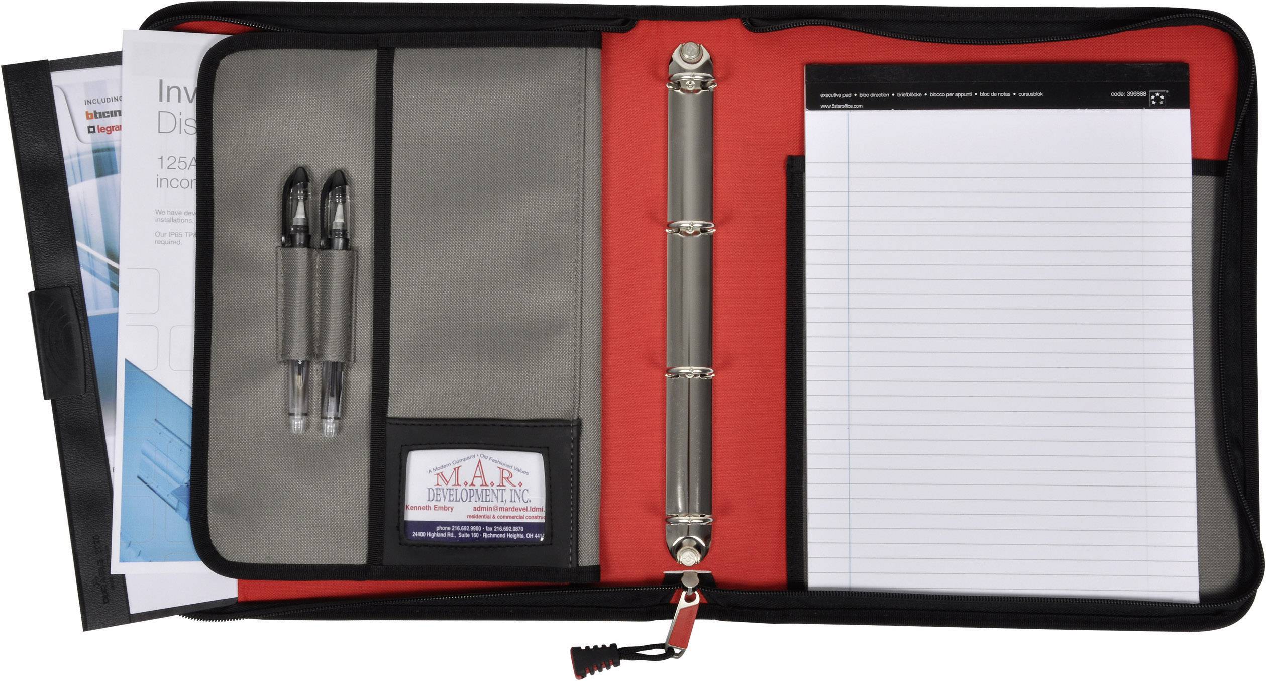 Une pochette noire ouverte avec un intérieur rouge, contenant deux stylos, un bloc de feuilles lignées et des brochures dans une pochette.