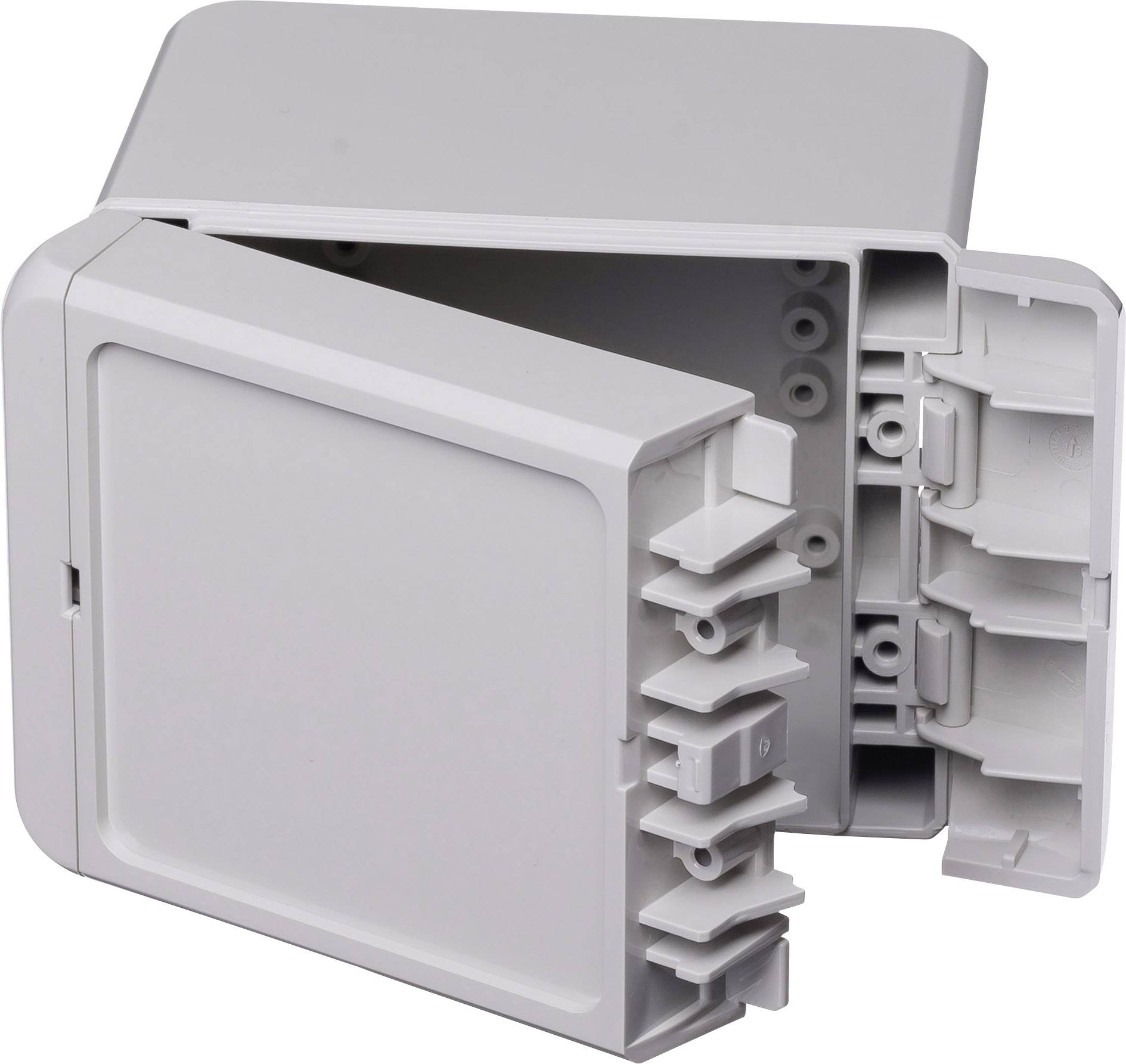 Une boîte de connexion grise et rectangulaire est partiellement ouverte, révélant son intérieur. Elle est utilisée pour le câblage.