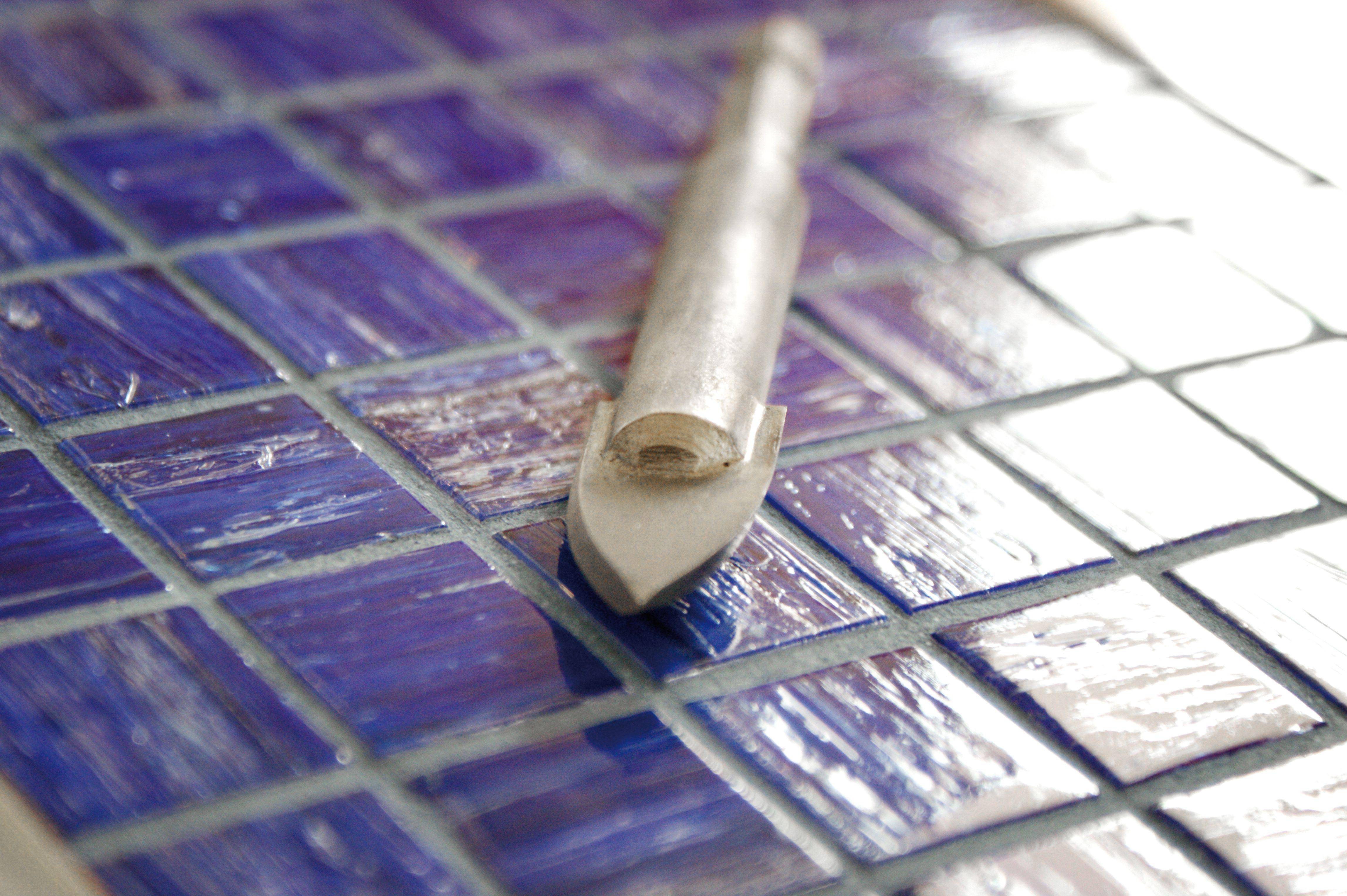 Coupe-carreaux sur une mosaïque bleue, prêt à couper. Matériaux de construction souvent utilisés pour des projets créatifs ou pratiques.