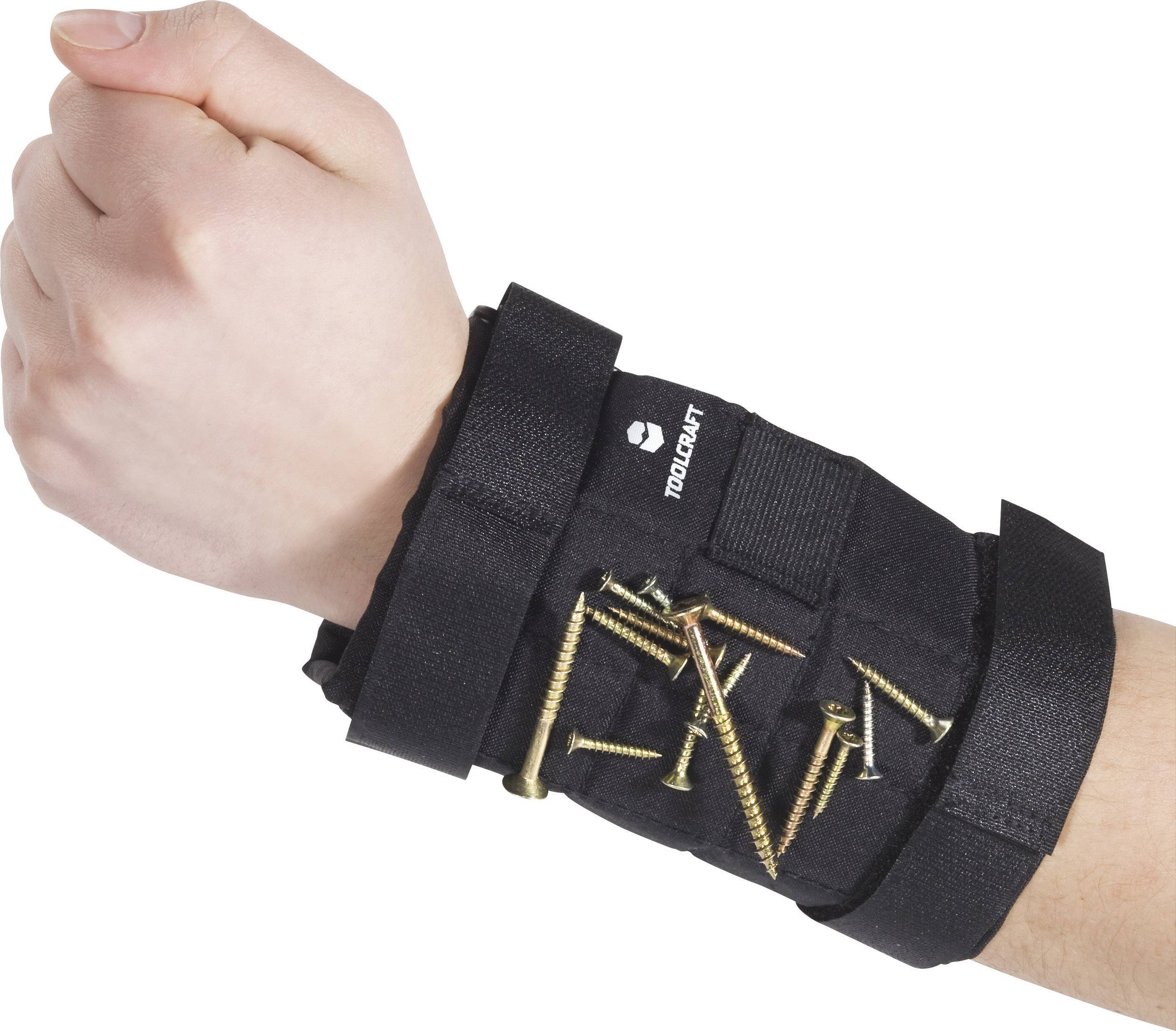 Un poignet, entouré d'un support magnétique noir avec des vis et des clous fixés dessus, montre l'utilité pratique de l'outil.