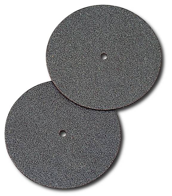 Deux disques abrasifs circulaires avec un trou central, superposés. Ils ont une surface rugueuse et sombre.