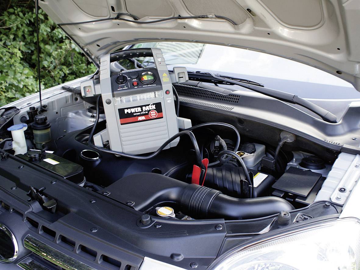 La batterie de voiture est rechargée avec un démarreur de secours portable dans le compartiment moteur.