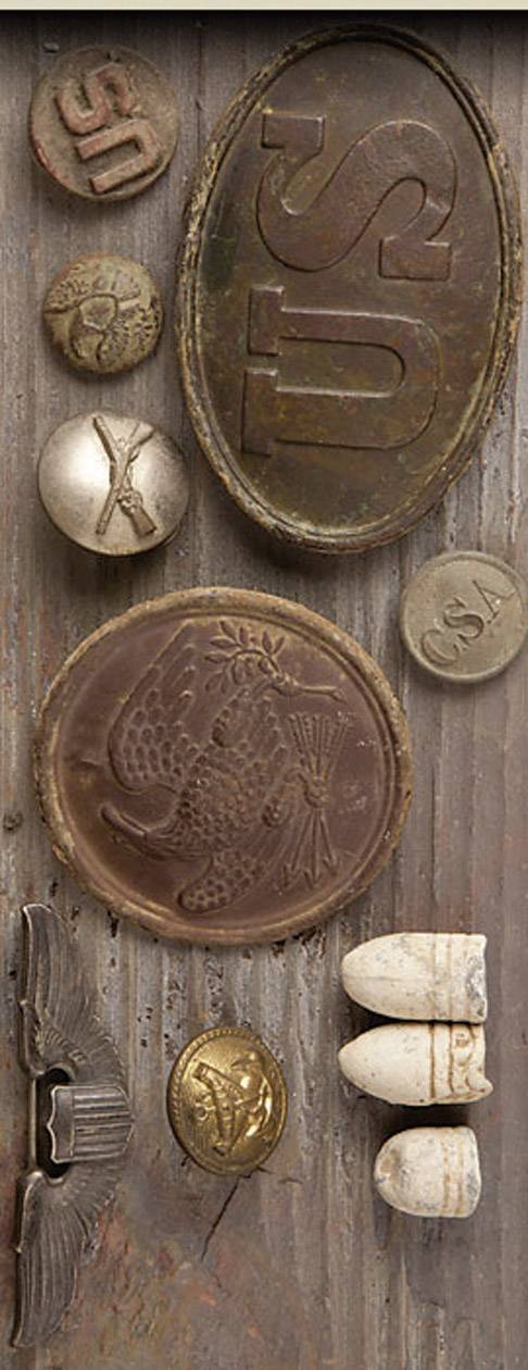 Divers éléments métalliques et en pierre estampés sur une surface en bois. Motifs principaux : poissons, lettres, symboles.