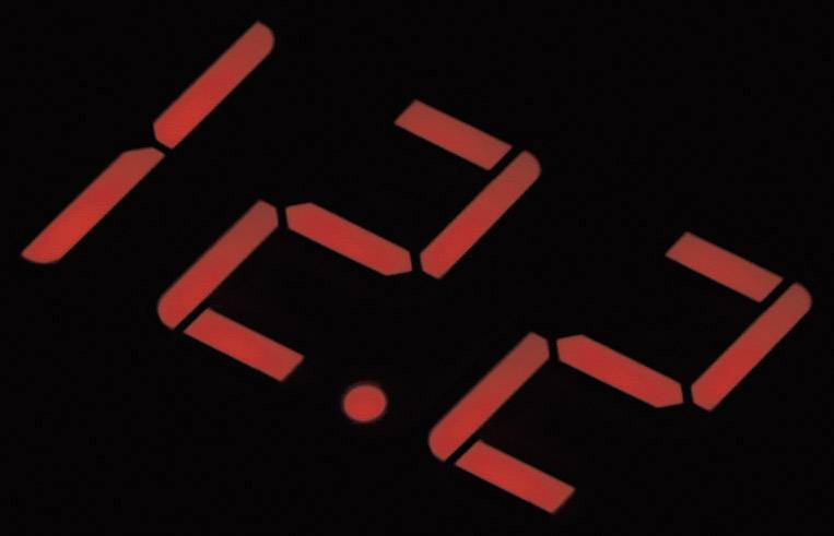 Affichage LED rouge indiquant l'heure '15:32'. Un fond sombre permet aux chiffres de ressortir nettement.
