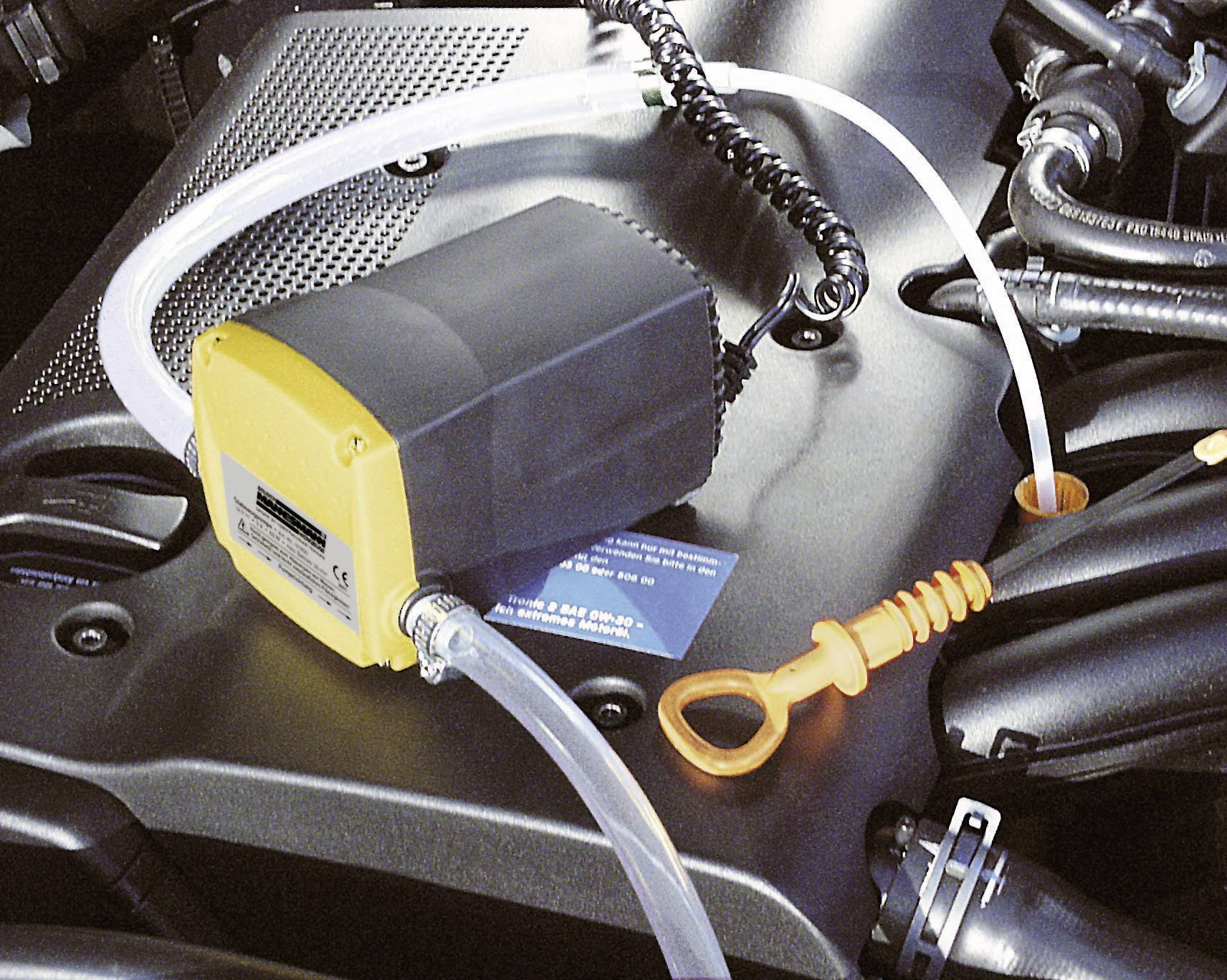 Un dispositif d'aspiration d'huile sur un moteur automobile, avec un tuyau raccordé et une jauge de niveau d'huile, prêt à effectuer une vidange.