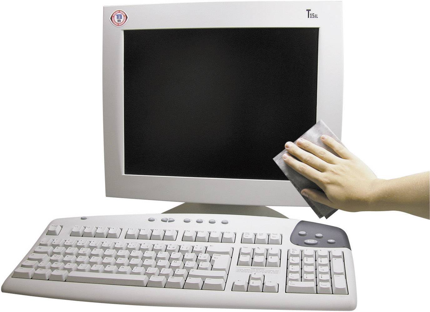 Une main essuie l'écran d'un ordinateur de bureau ; un clavier est posé devant.